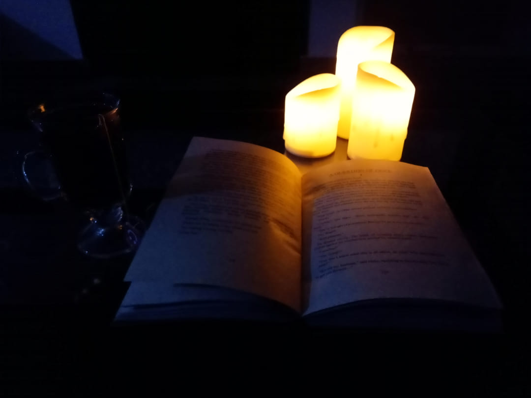 Open book cozily lit by candles